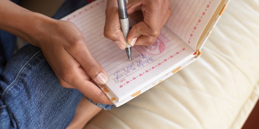 Woman writing journal prompts